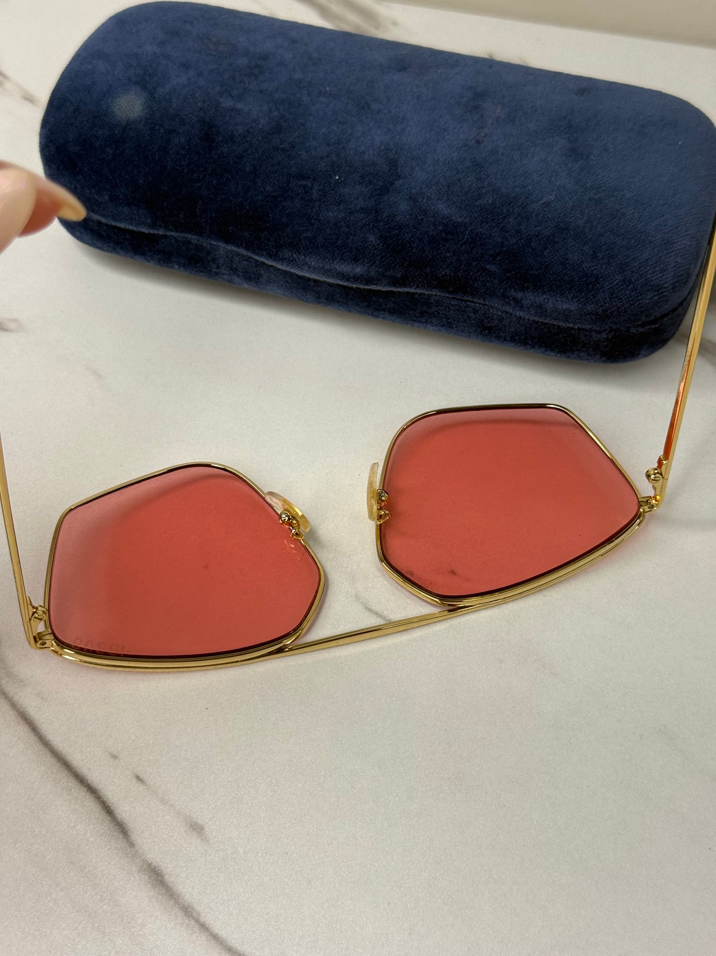 Gucci GG0437SA sunglasses featuring a gold metal frame and pink lenses
