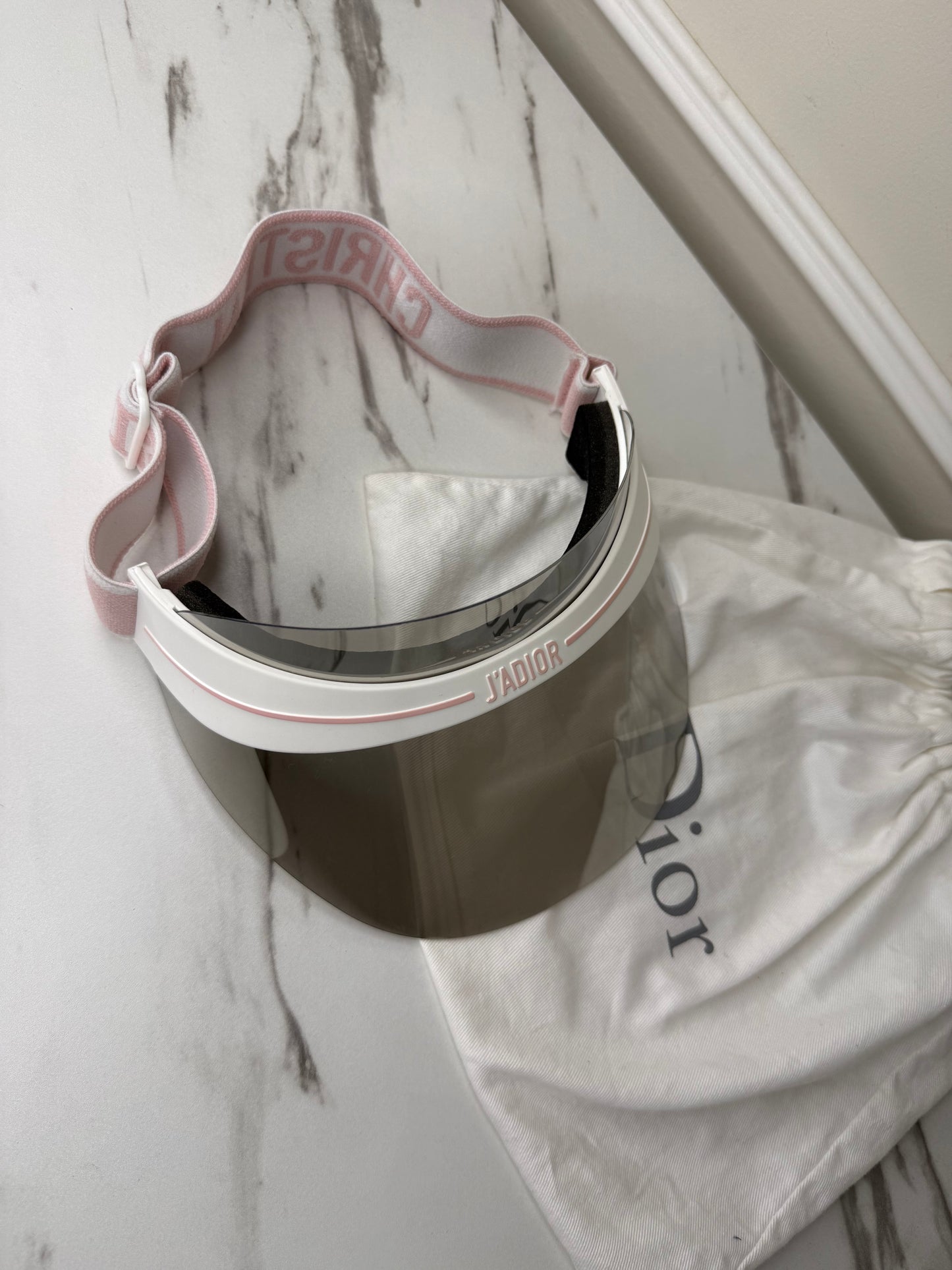 Dior Club 1 sun visor in pink and white with a grey lens