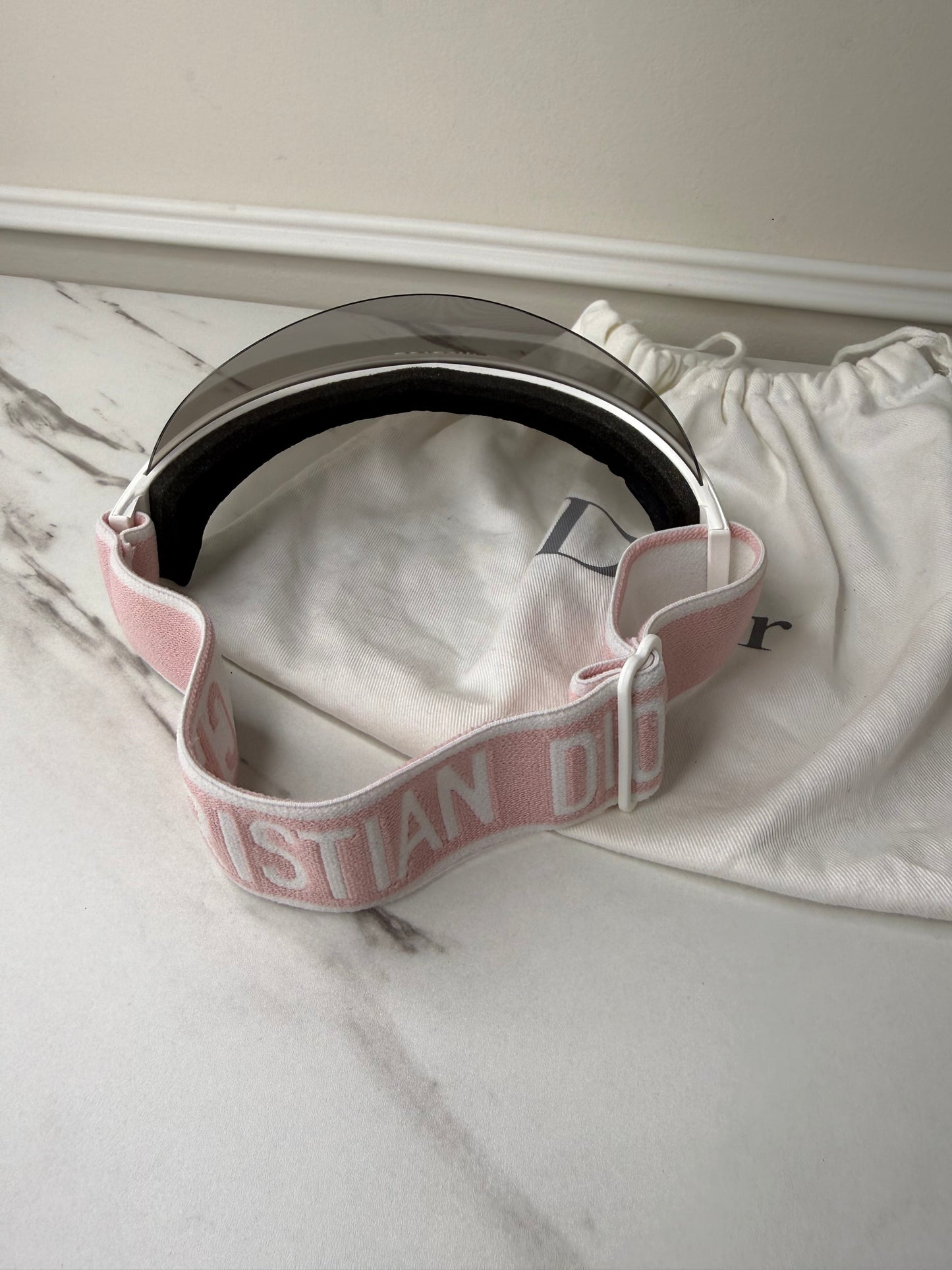 Dior Club 1 sun visor in pink and white with a grey lens