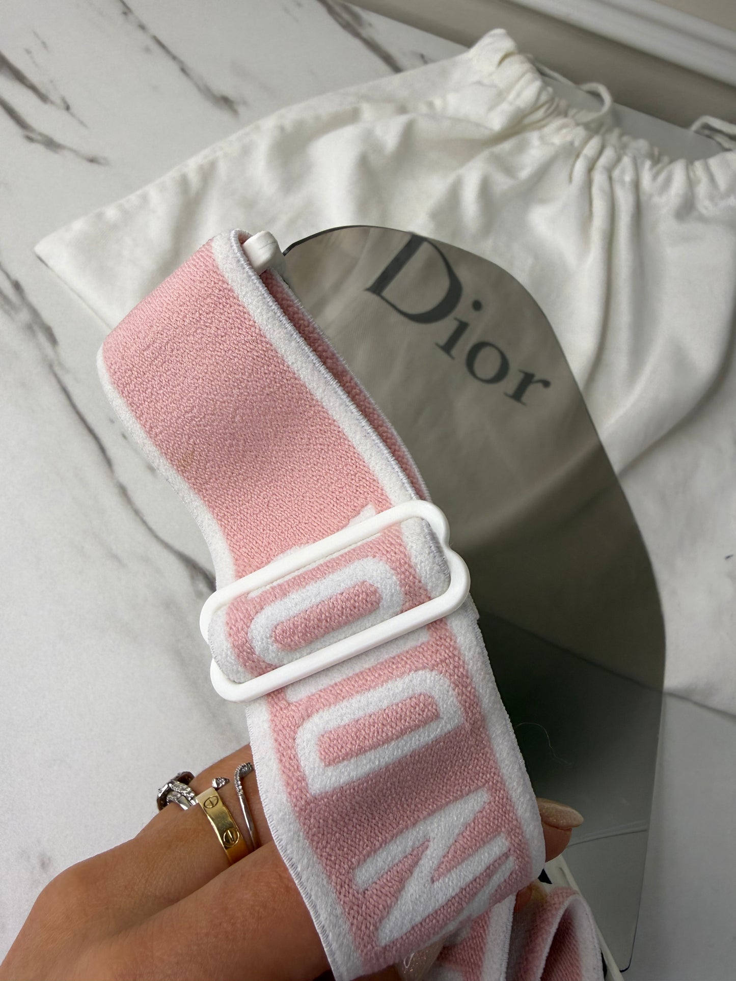 Dior Club 1 sun visor in pink and white with a grey lens