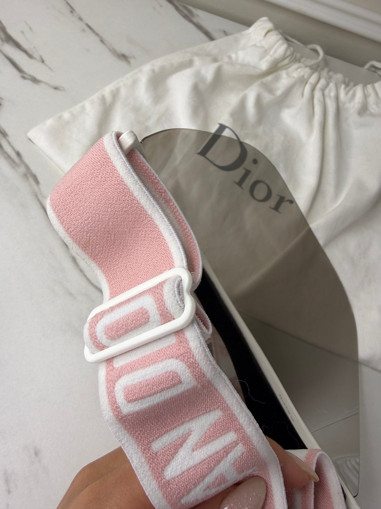 Dior Club 1 sun visor in pink and white with a grey lens
