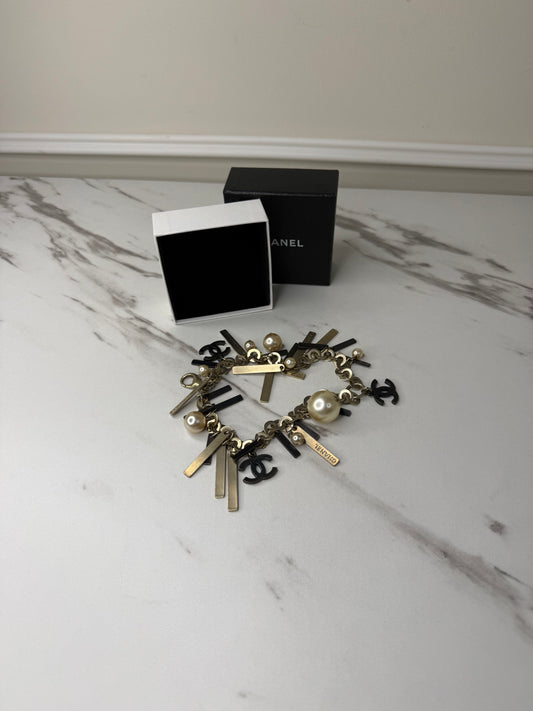 Chanel Logo Charm Bracelet featuring gold and black metal charms and faux pearls