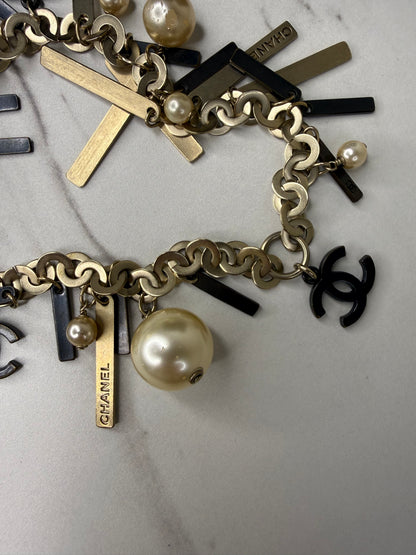 Chanel Logo Charm Bracelet featuring gold and black metal charms and faux pearls