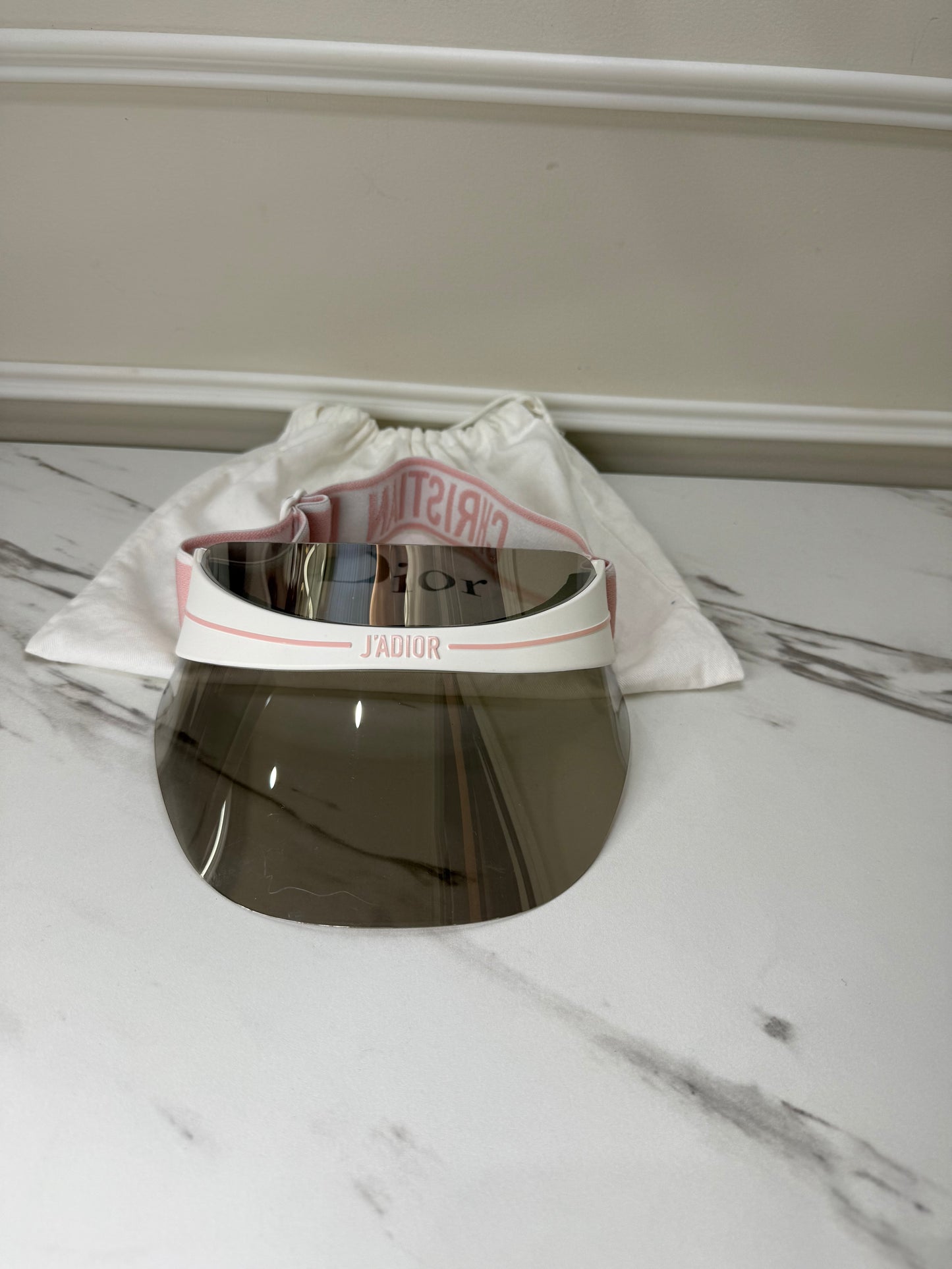 Dior Club 1 sun visor in pink and white with a grey lens